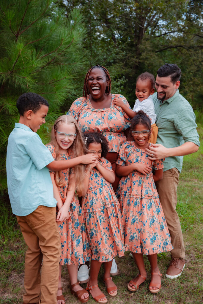 Family wearing matching pink and blue outfits outfide.